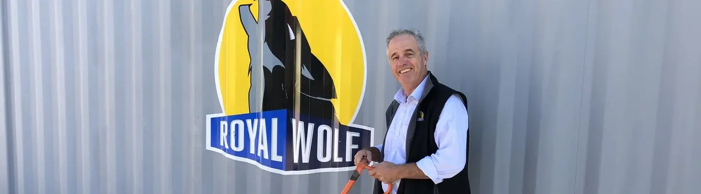 Manager standing in front of a shipping container at a construction site, overseeing barrier placement and site safety measures.