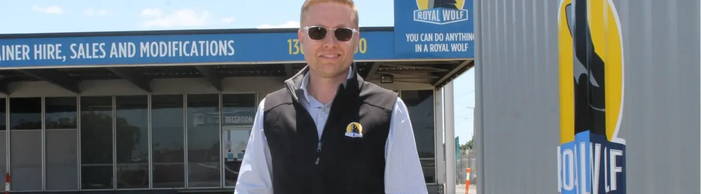 Company manager standing in front of the company building, overseeing operations related to construction safety and barrier solutions.
